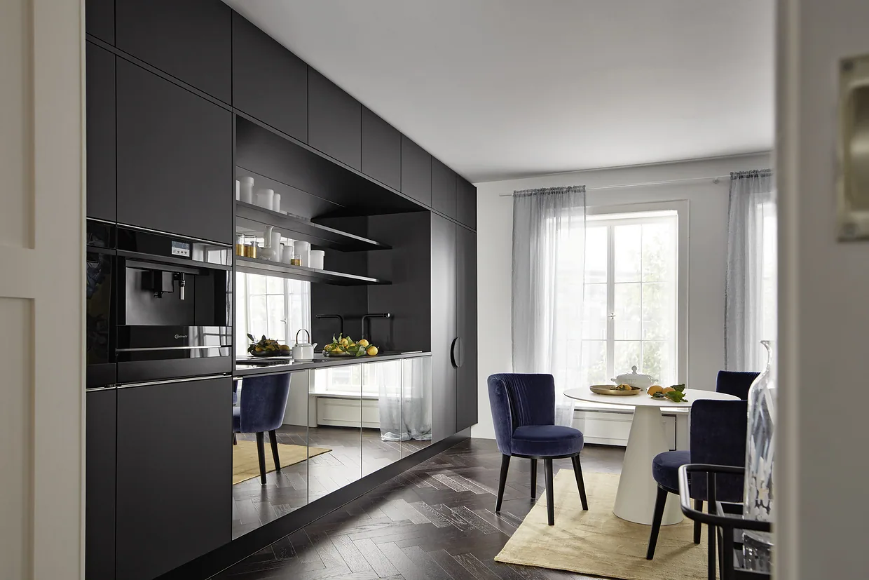 Bucătărie nolteneo neagră mată într-un apartament clasic, cu scaune de catifea albastră