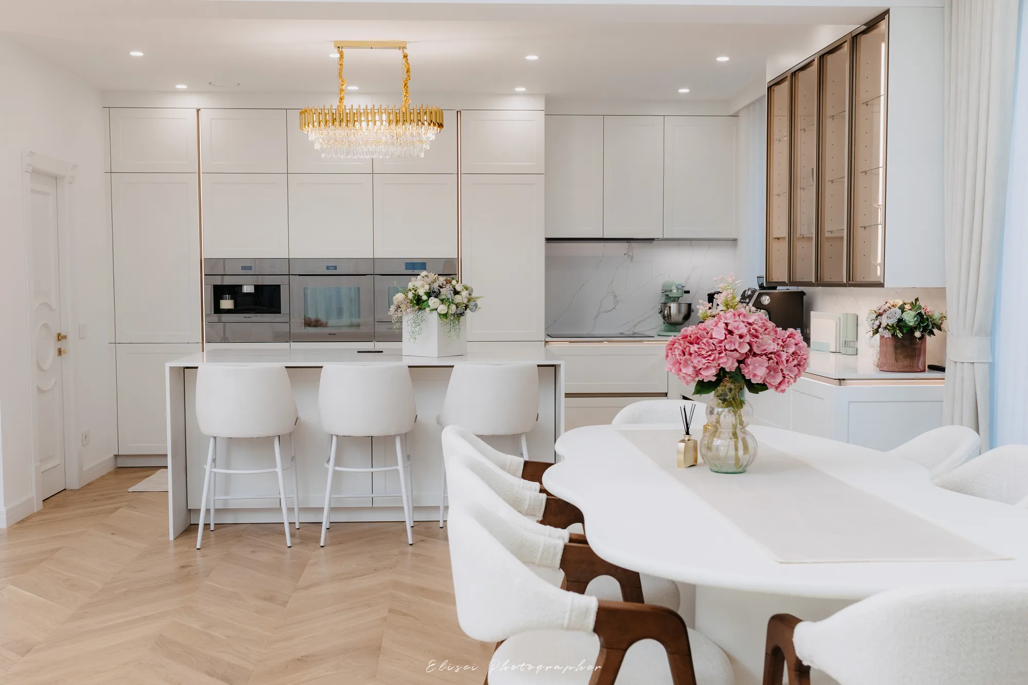 Bucătăria deschisă către zona de dining, cu insulă din quartz Calacatta